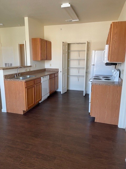 A kitchen with wooden cabinets and a white fridge.