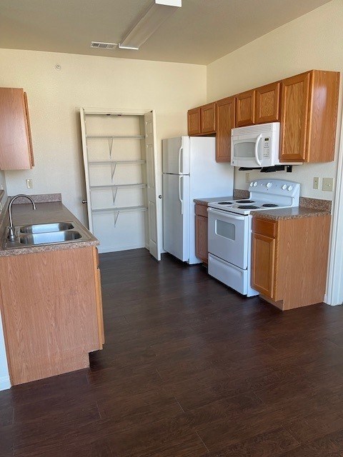 A kitchen with wooden cabinets and a white refrigerator.