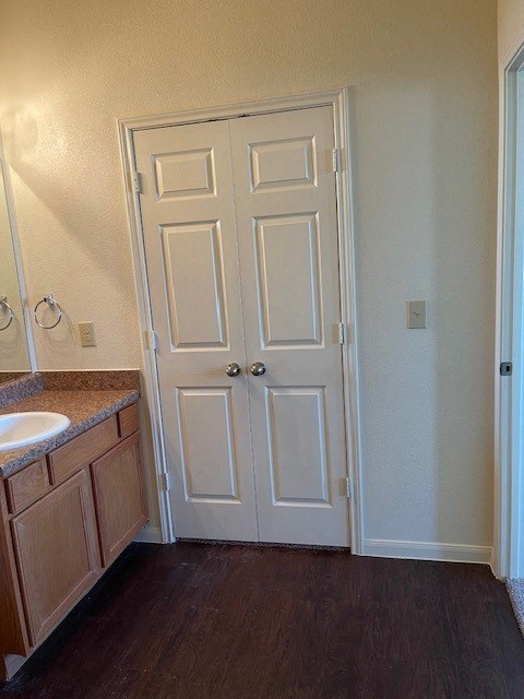 A white door with a black handle is in a room with a brown floor.