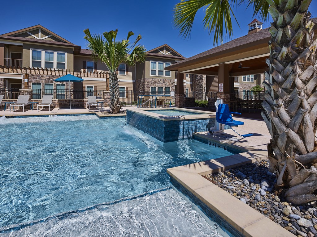 A person is sitting on a blue chair by a pool.
