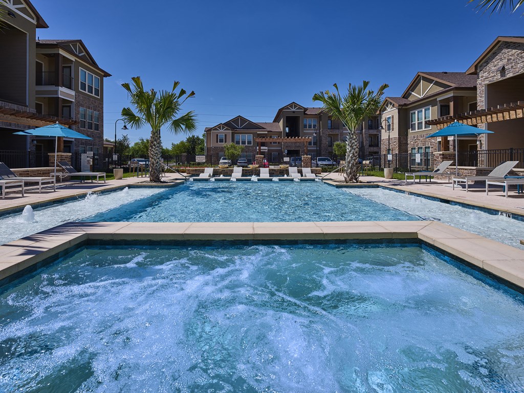 A large pool with a hot tub in the middle of a residential area.
