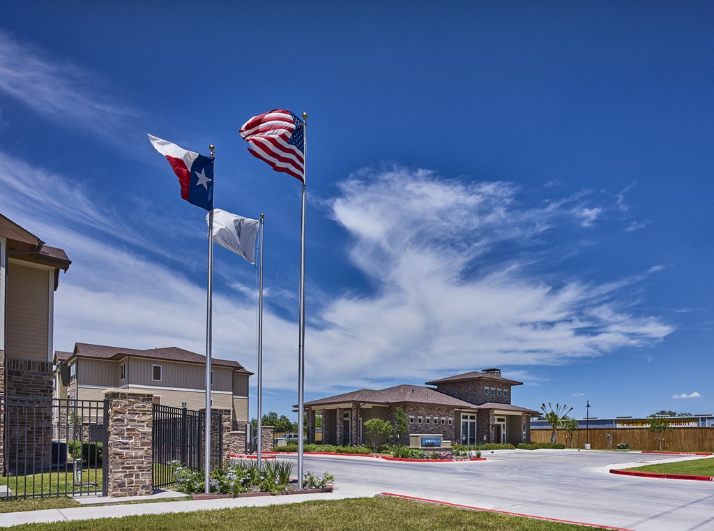 A building with a Texas flag and an American flag on flagpoles in front of it.