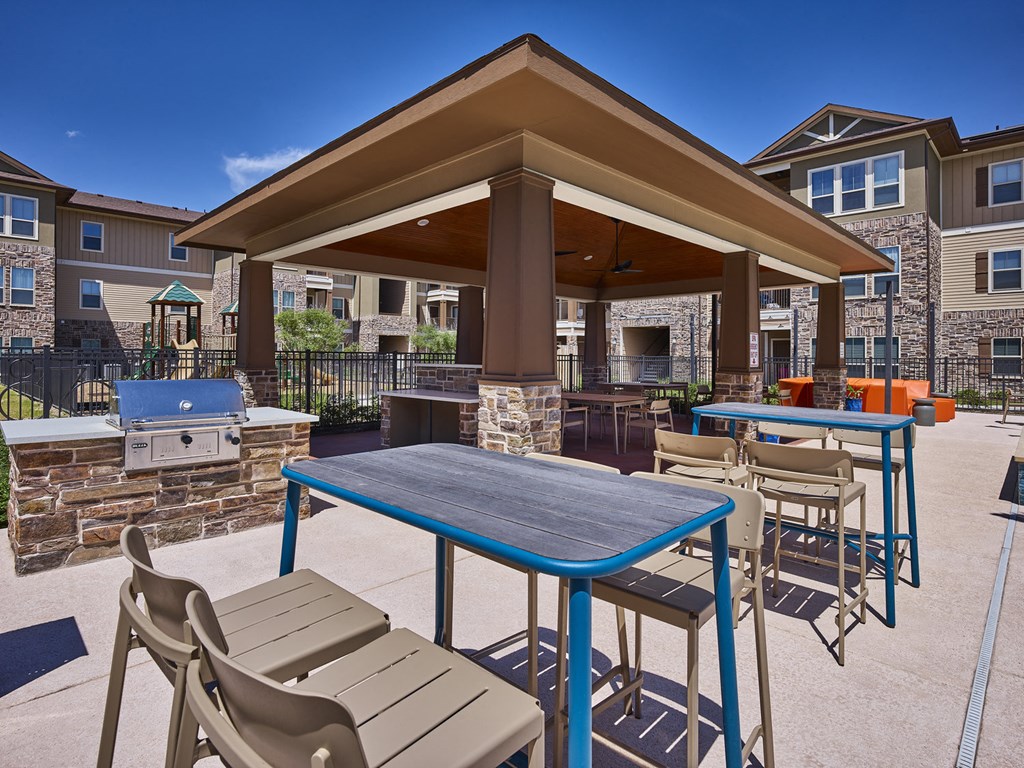 A patio with a table and chairs is surrounded by apartment buildings.