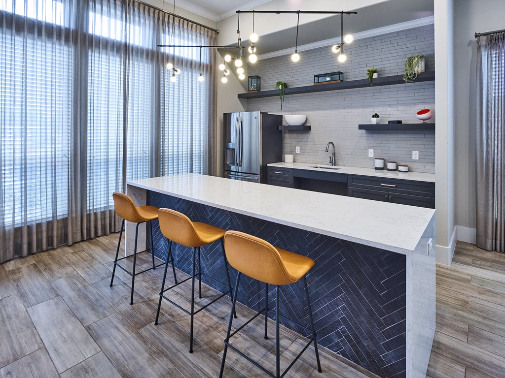 A kitchen with a bar area and chairs.