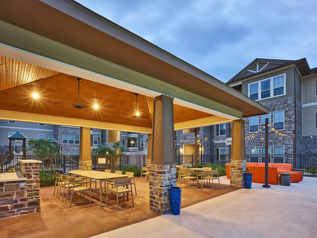 A patio with a table and chairs under a roof.