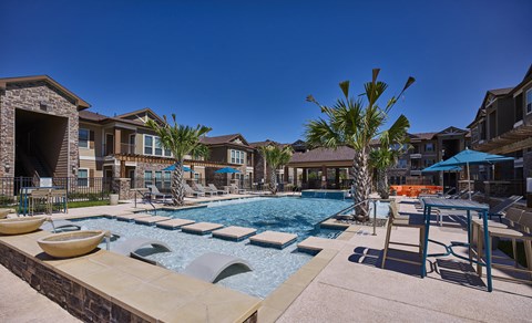 A pool with a slide and a palm tree in the foreground.