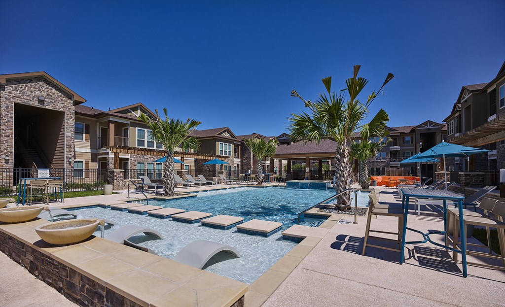A pool with a slide and a palm tree in the foreground.