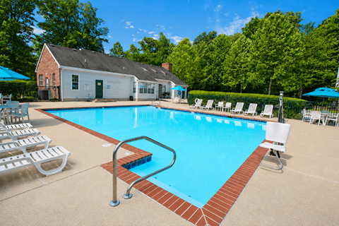 A pool with a red brick border and a diving board.