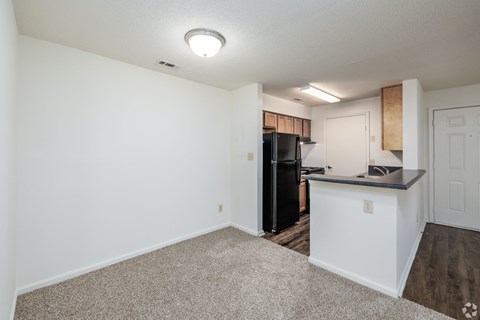 A kitchen area with a black refrigerator and a white countertop.