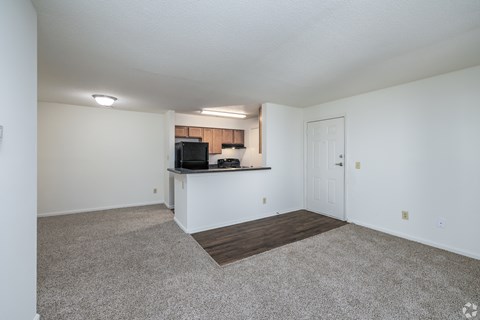 A spacious living room with a television and a bar area.