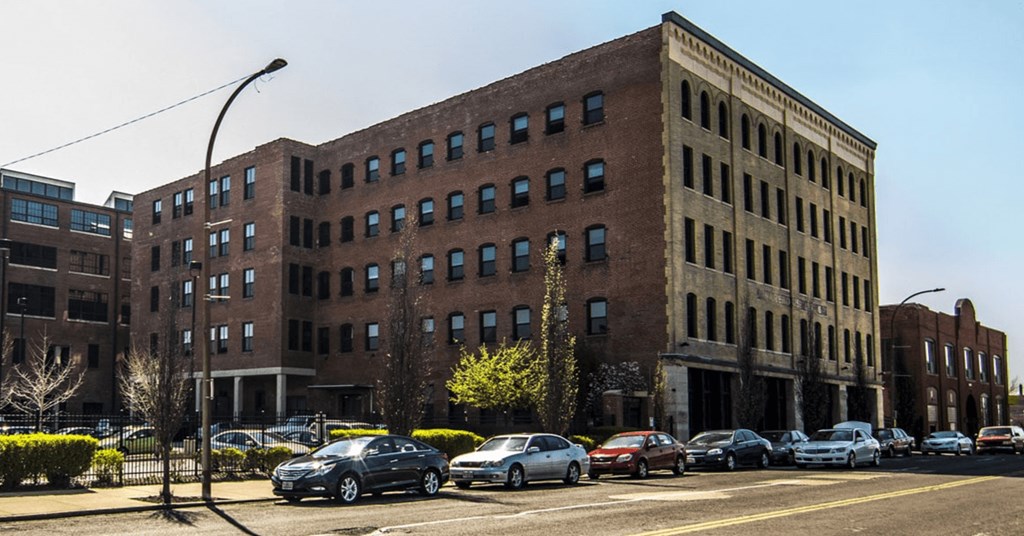 a large brick building on a city street with cars parked