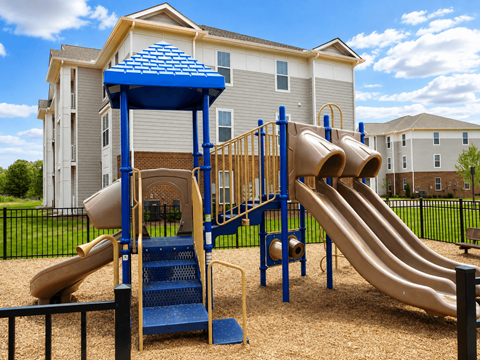 A playground with a blue and yellow slide and a wooden structure.