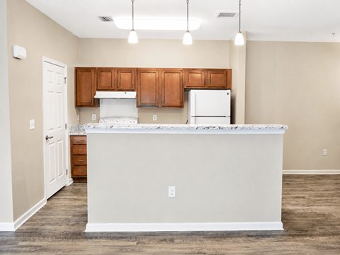 A kitchen with a white counter and brown cabinets.