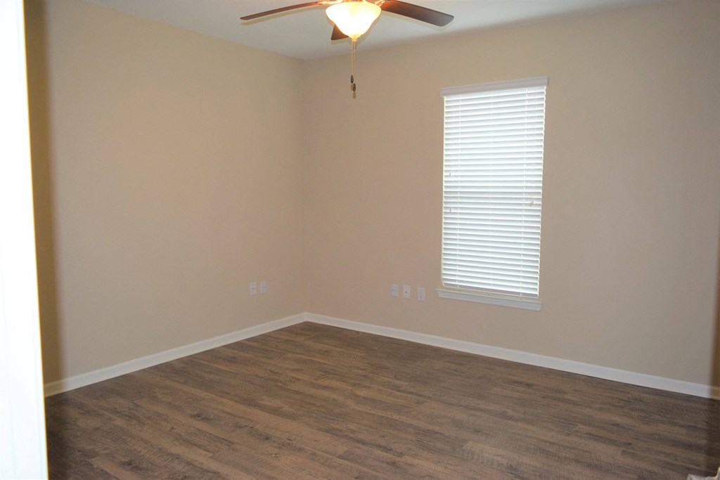 a living room with wood floors and a ceiling fan