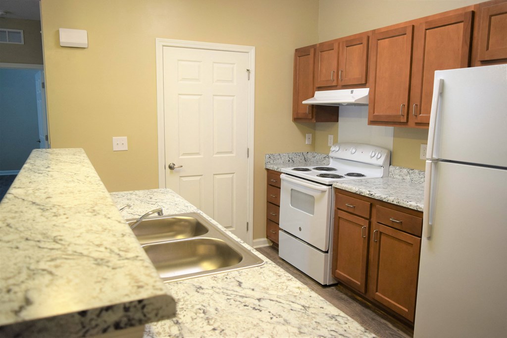 a kitchen with white appliances and granite counter tops
