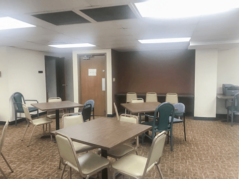 A conference room with a long table surrounded by chairs.