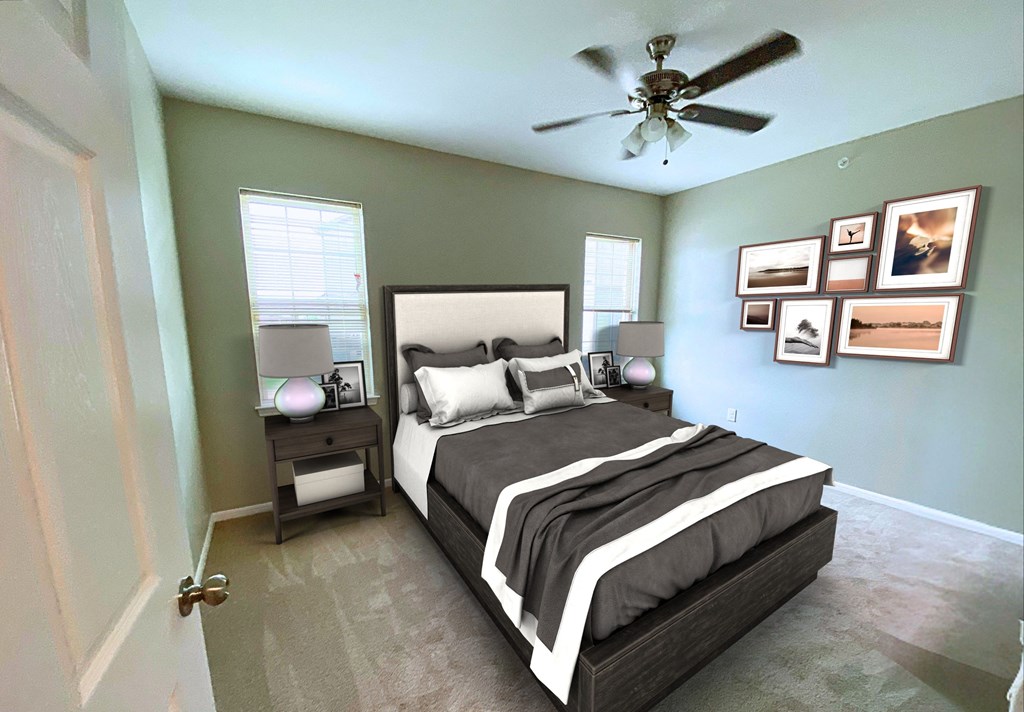 A bedroom with a large bed and a ceiling fan.