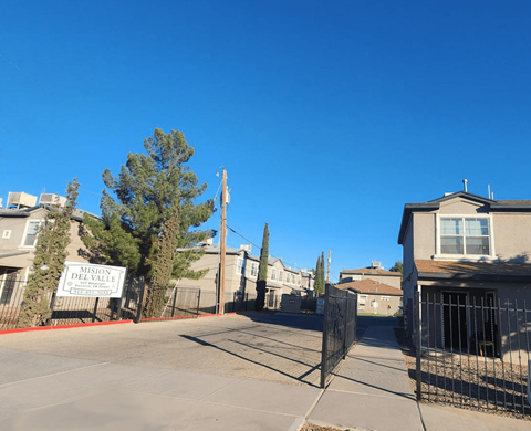 A street view of a residential area with a sign that reads "Mission Del Valle.".