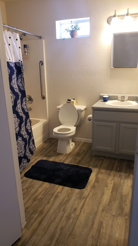 A bathroom with a toilet, sink, and shower curtain.