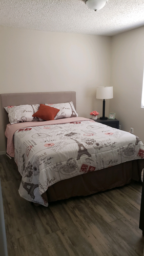 A bed with a white comforter and a red pillow is in the room.