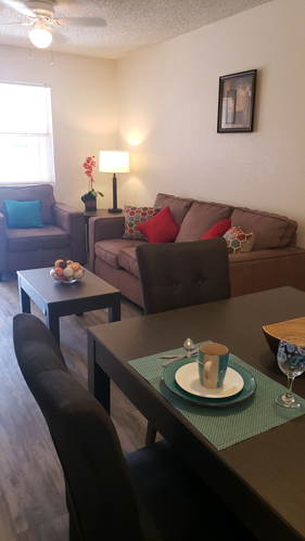 A living room with a brown couch, a coffee table, and a lamp.