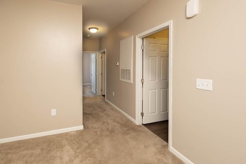 a hallway with a door to a bedroom and a closet