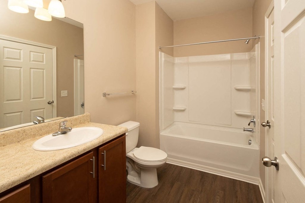 A bathroom with a toilet, sink, and bathtub.