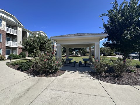 a pavilion with a seating area in front of an apartment building