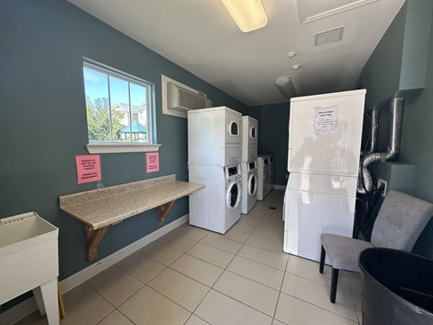 a laundry room with washer and dryer and a table with a washing machine