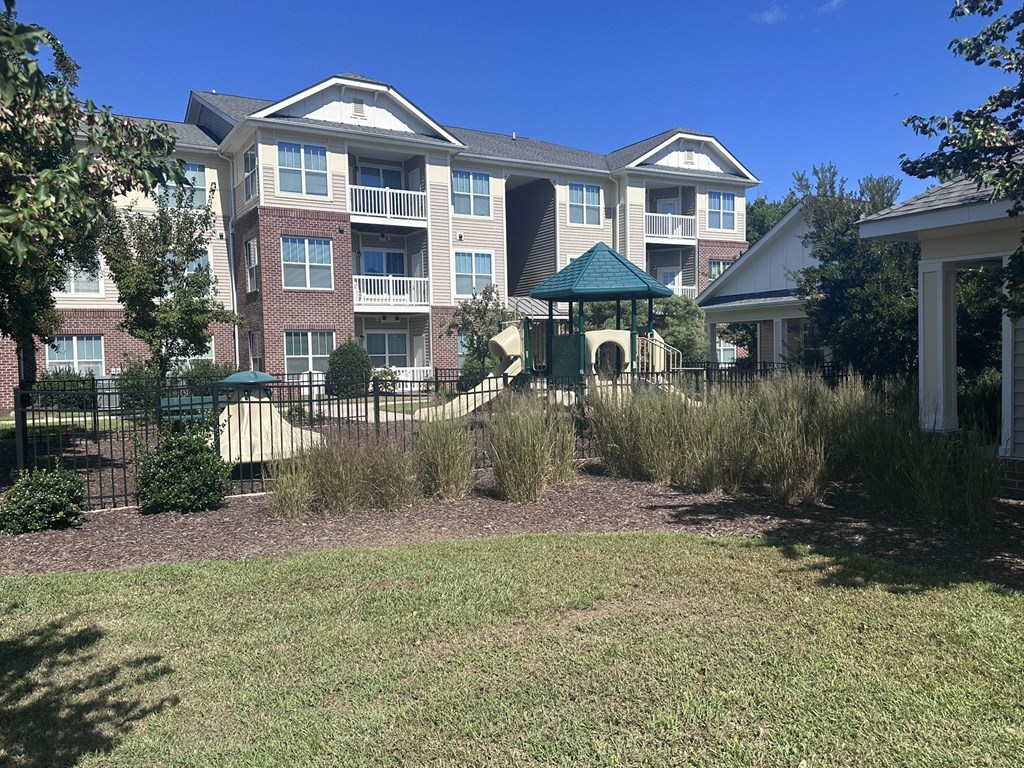 an apartment building with a yard and a gazebo