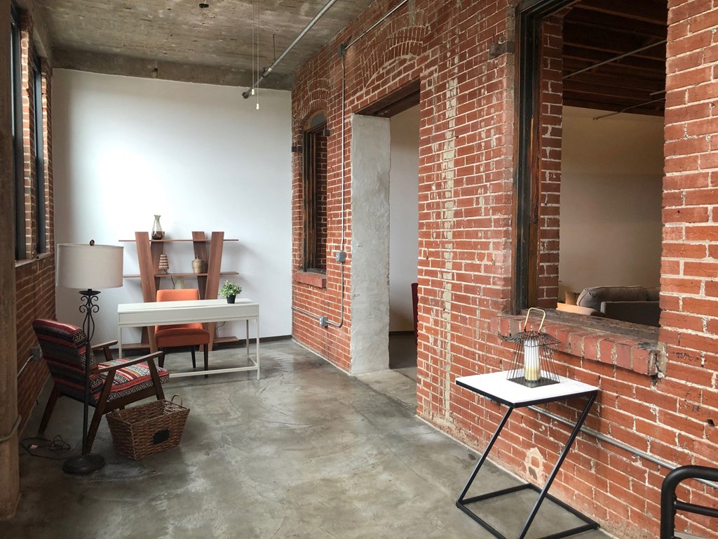 a living room with a brick wall and a table