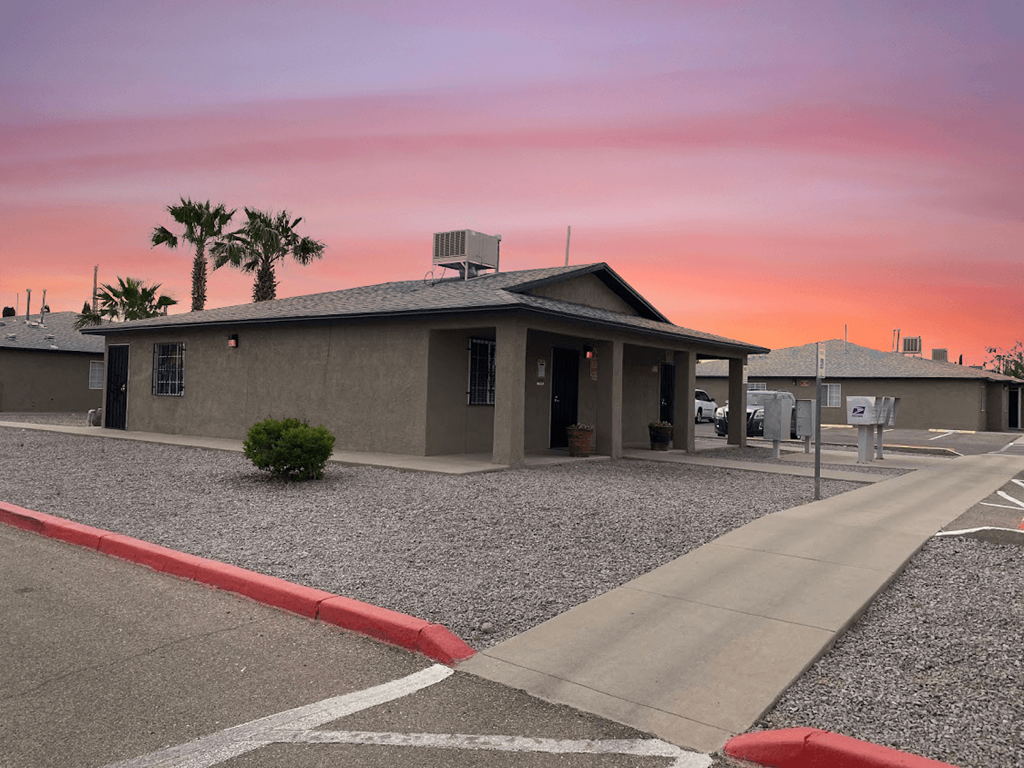 a parking lot in front of a building with a pink sky