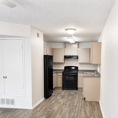 A kitchen with black appliances and white walls.
