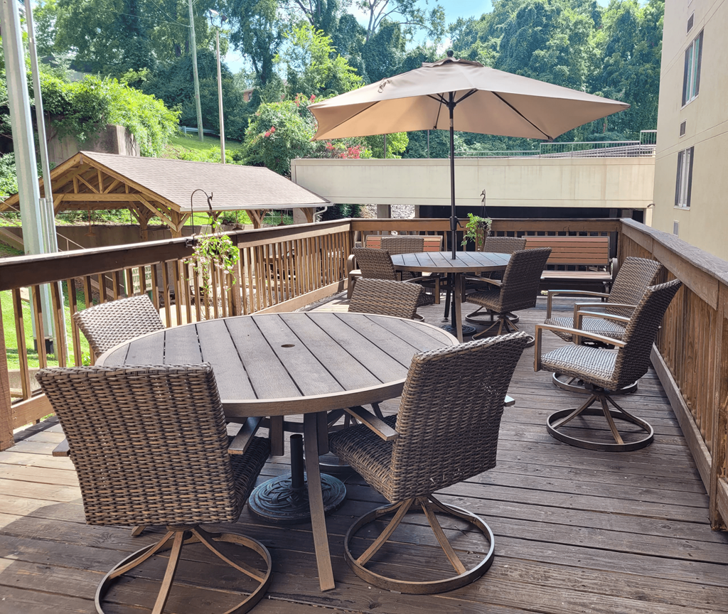 an outdoor patio with tables and chairs and an umbrella