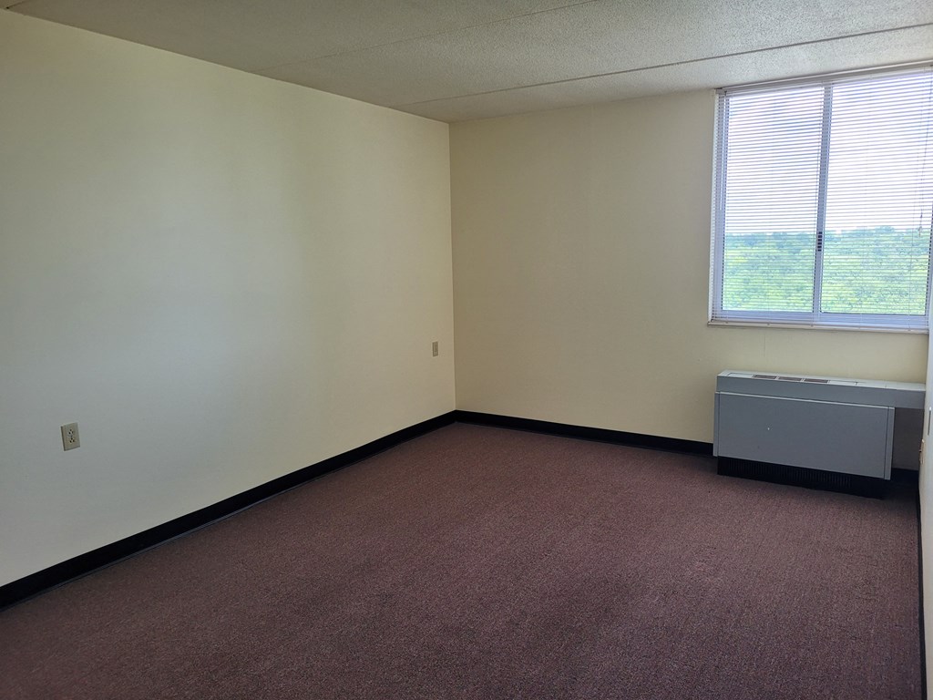 an empty room with a radiator and a window