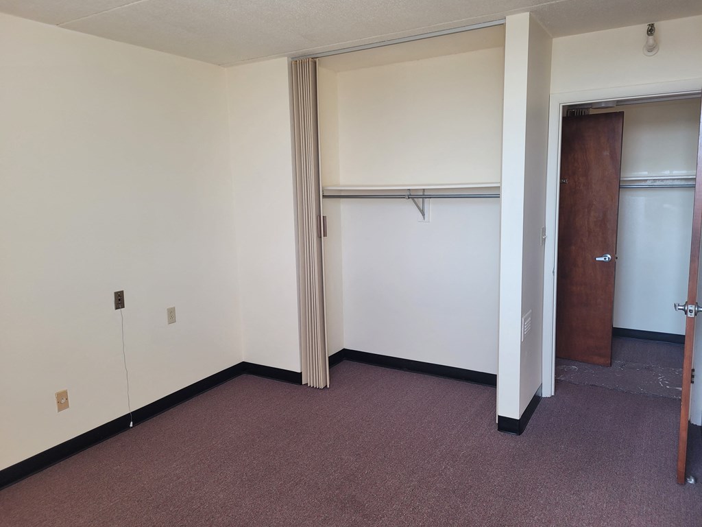 a small room with a closet and a door that is open