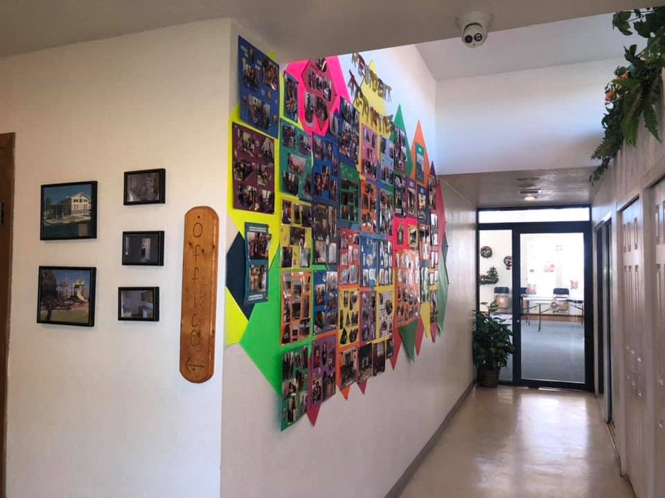 a wall in a hallway with a collage of photos on it