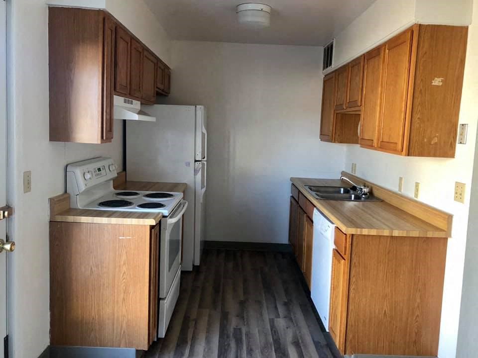 an empty kitchen with a stove refrigerator and sink