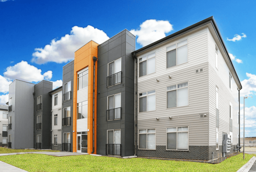 a row of new apartment buildings in front of a blue sky