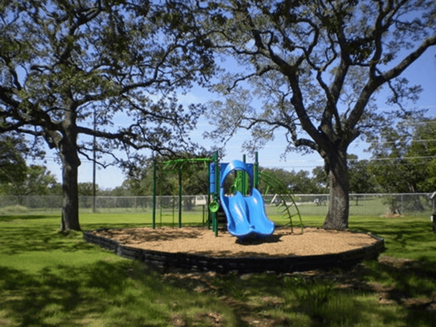 a playground with a blue slide in a park