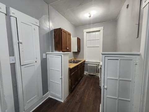 A kitchen with white cabinets and a wooden counter.