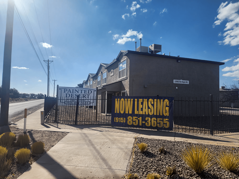 A sign for a Painted Desert motel is displayed in front of a building.