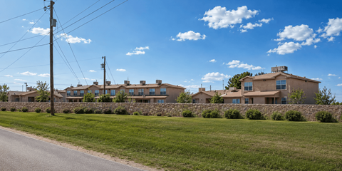 A row of houses with a stone wall in front.