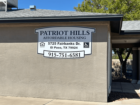 A sign for Patriot Hills Affordable Housing is on the side of a building.