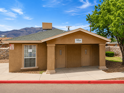 A small building with a brown roof and a sign that says "Office" on it.