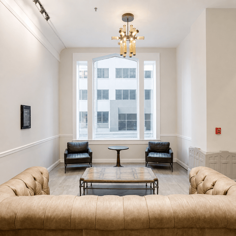 A living room with a large window and a chandelier.