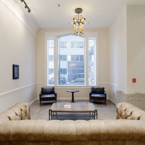 A living room with a couch, chairs, and a table.