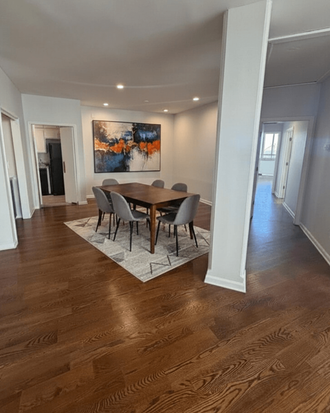 A dining room with a wooden table and chairs.