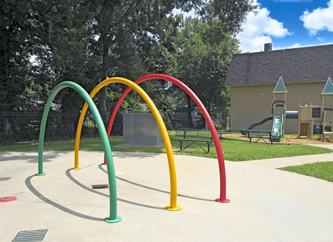 A playground with a red, yellow, green and blue arch.
