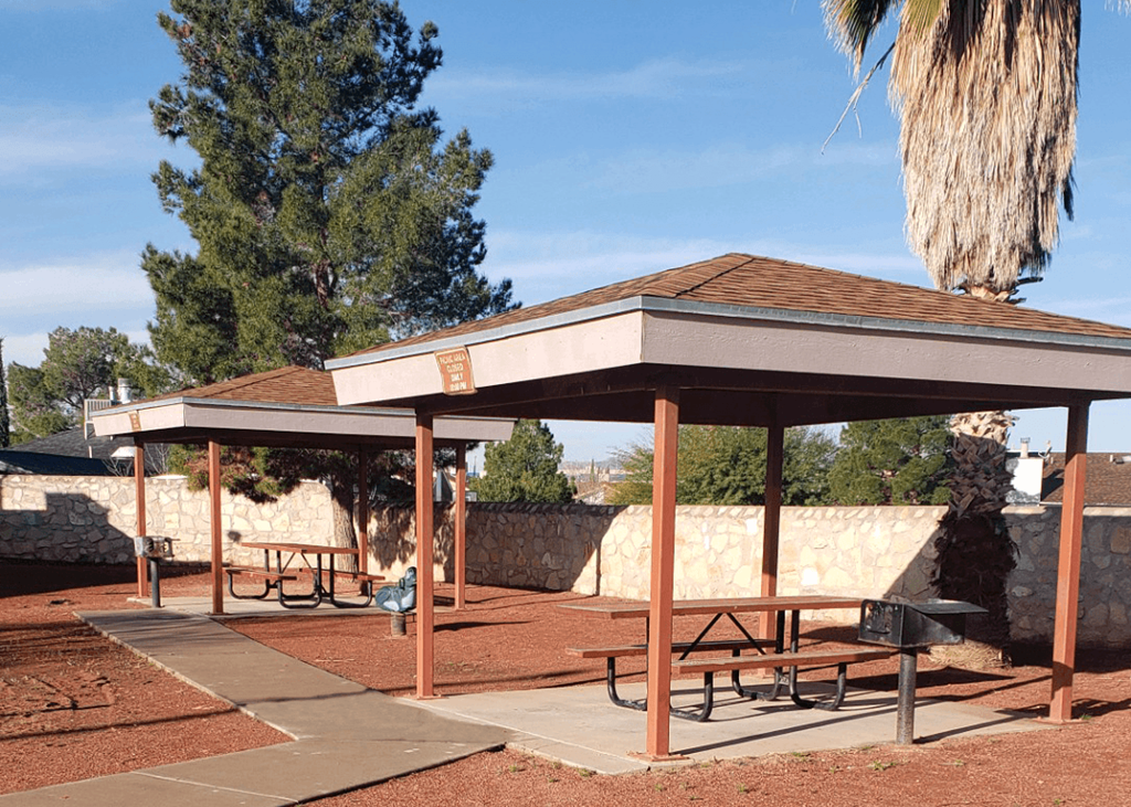 a picnic pavilion with benches in a park